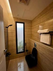 a bathroom with a black chair in a room with a window at Onyx residence in Riyadh