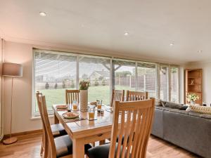 a dining room with a table and chairs and a couch at 3 Bed in Stalham 91479 in Stalham