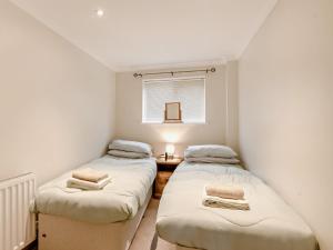 Habitación pequeña con 2 camas individuales y mesa. en 3 Bed in Stalham 91479, en Stalham