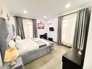 Tribeca pod (3 bedroom with swimming pool) V.i Lagos في لاغوس: غرفه فندقيه بسرير واريكه