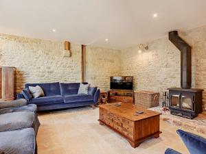 a living room with a blue couch and a fireplace at 4 Bed in Melbury Abbas 91456 in Melbury Abbas