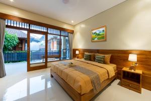 a bedroom with a large bed and a large window at Rahayu Hanoman Ubud in Ubud