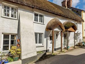 a white cottage with a thatched roof at 1 Bed in Barnstaple 91612 in Bishops Tawton