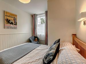 a bedroom with a bed and a chair and a window at 2 Bed in Boulmer 91486 in Boulmer