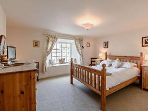 a bedroom with a wooden bed and a window at 2 Bed in Middleham 91639 in Middleham