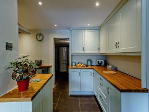 a kitchen with white cabinets and a wooden counter top at 2 Bed in Bridgnorth 91551 in Bridgnorth