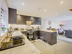 a kitchen with stainless steel appliances and a living room at 2 Bed in Barnstaple 91637 in Fremington