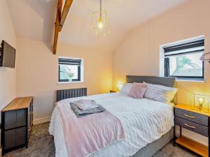 a bedroom with a bed and a dresser and two windows at 2 Bed in Barnstaple 91637 in Fremington