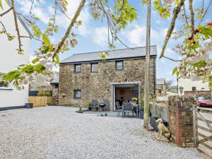 an exterior view of a stone house with a patio at 2 Bed in Barnstaple 91637 in Fremington