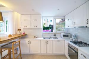 a white kitchen with white cabinets and a sink at Kalkan Suites 103 in Kalkan