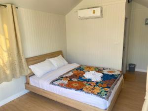 małą sypialnię z łóżkiem z kwiatowym kocem w obiekcie The Pubpa Backyard 