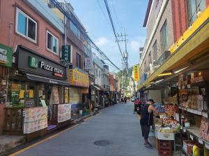 a woman is standing in a street in a market at Newly renovated hidden gem #2 in Seoul
