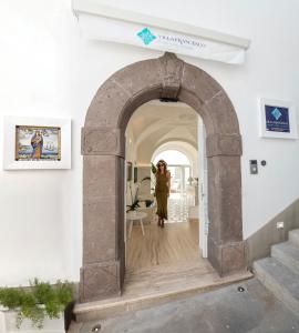 a woman walking through an archway in a building at Villa Francesco Luxury Suites in Positano