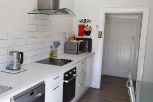 a white kitchen with a stove and a sink at Blackbird Cottage - Stunning views & farm animals in Tanunda