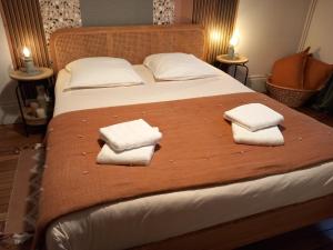 a bed with two towels on top of it at Passage de l'Horloge in Auxerre