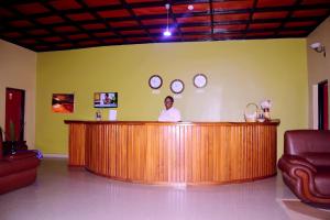 a man standing at a bar in a room at La Natura Guest House in Ruhengeri