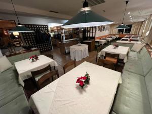 ein Restaurant mit Tischen und Stühlen mit Blumen darauf in der Unterkunft Pension Alpina in Obsteig