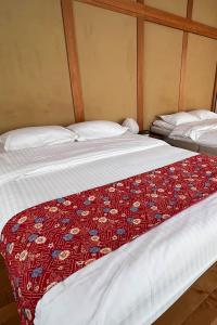 two beds sitting next to each other in a room at Hondori Inn in Hiroshima