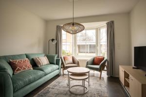 a living room with a green couch and a table at Dormio Resort Berck-sur-Mer in Berck-sur-Mer