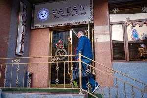 a man standing on the front door of a building at VATAN DUSHANBE HOTEL in Dushanbe