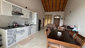 cocina y sala de estar con mesa y sillas. en Chathu Holiday Home en Kandy