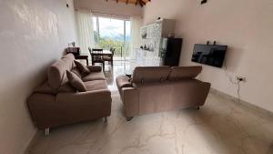 a living room with two couches and a television at Chathu Holiday Home in Kandy