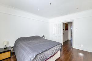 Chancery's Loft Private Apartment في لندن: غرفة نوم بيضاء مع سرير وأرضية خشبية