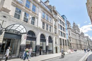 people walking on a street in front of a building at Chancery's Loft Private Apartment in London