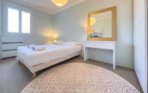 a bedroom with a bed with a mirror and a dresser at Le Trendy by Winsome Destination in Cannes