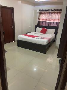 a bedroom with a bed with a red pillow at HOTEL MOUNTAIN PARADISE in Bangalore +1 photo
