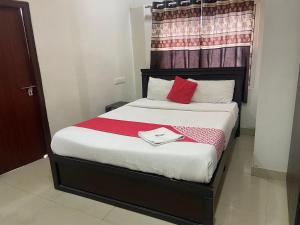 a bed with two red pillows on it in a room at HOTEL MOUNTAIN PARADISE in Bangalore