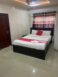 a bedroom with a large bed with red pillows at HOTEL MOUNTAIN PARADISE in Bangalore