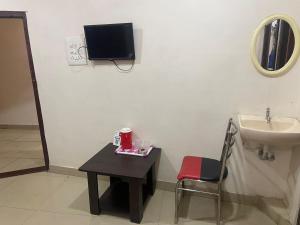 a bathroom with a sink and a table with a chair at HOTEL MOUNTAIN PARADISE in Bangalore