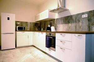 a large kitchen with white cabinets and appliances at Luxury Three-Bedroom Apartment in Teplice