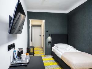 a bedroom with a bed and a flat screen tv at Żbik in Spała