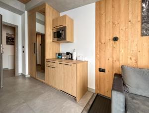 a kitchen with wooden cabinets and a microwave at Apartamenty Krupówki 20 in Zakopane