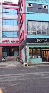 una strada cittadina con un edificio con negozi e una panchina di HOTEL ANAND a Jhansi