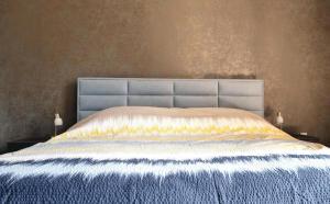 Luxury Three-Bedroom Apartment في تبليتسه: غرفة نوم مع سرير كبير مع اللوح الأمامي الأزرق