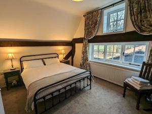 a bedroom with a bed and a window at Gardener's Cottage, Knebworth Park in Knebworth