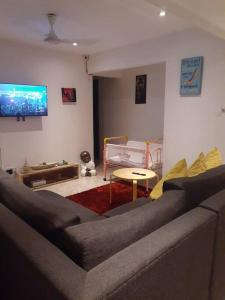 a living room with a couch and a tv at Entire 3 bedroom Fully Furnished House, 6 Guests in Suva