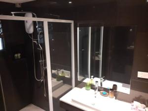 a bathroom with a shower and a sink and a mirror at Entire 3 bedroom Fully Furnished House, 6 Guests in Suva