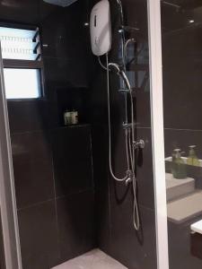 a shower in a black bathroom with a shower head at Entire 3 bedroom Fully Furnished House, 6 Guests in Suva