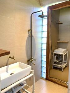 uma casa de banho com um lavatório branco e um espelho. em Tropical Garden Oasis Villa em Phu Quoc