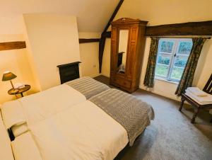 a bedroom with a large bed and a window at Gardener's Cottage, Knebworth Park in Knebworth
