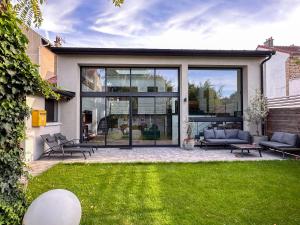 a house with large windows and green grass at Magnifique maison familiale - Idéalement située pour les JO 2024 in Colombes