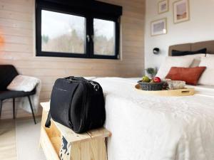 a black bag sitting on a bed with a tray of fruit at RA House Plitvice Lakes in Bročanac