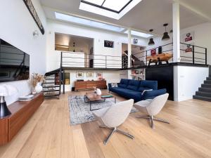 a large living room with a blue couch and chairs at Magnifique maison familiale - Idéalement située pour les JO 2024 in Colombes