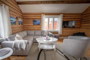 ein Wohnzimmer mit einem Sofa und einem Tisch in der Unterkunft Explorers Cabin Lofoten Edge in Sørvågen