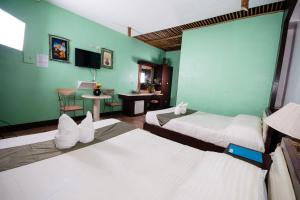 Habitación de hotel con 2 camas y mesa en San Remigio Beach Club, en San Remigio