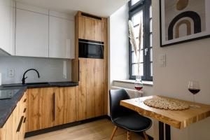 a kitchen with a wooden counter and a table with a glass of wine at GA Wroclaw&Jana Pawla- Free Parking in Wrocław